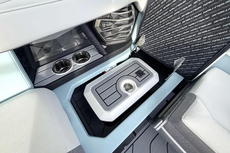 Slide: The Image of 2026 Nautique Super Air Nautique G21 interior with storage compartment and cup holders. - 27