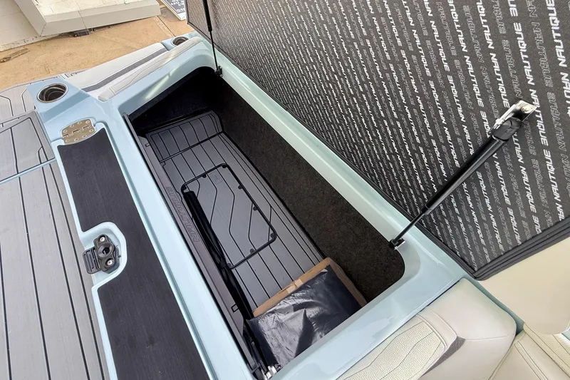 Slide: The Image of 2026 Nautique Super Air Nautique G21 storage compartment with open lid and interior view. - 29