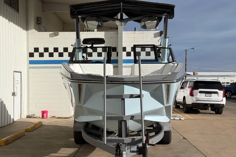 Slide: The Image of 2026 Nautique Super Air Nautique G21 boat on trailer, parked outside a building. - 3