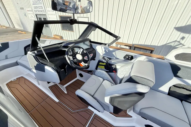 Slide: The Image of 2026 Nautique Super Air Nautique GS22 interior with modern helm and seating. - 14
