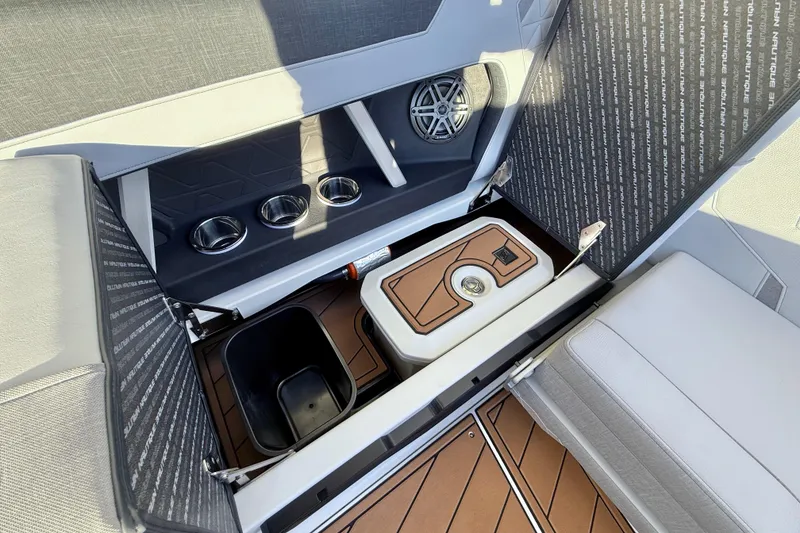 Slide: The Image of 2026 Nautique Super Air Nautique GS22 interior storage with cup holders and speaker. - 18