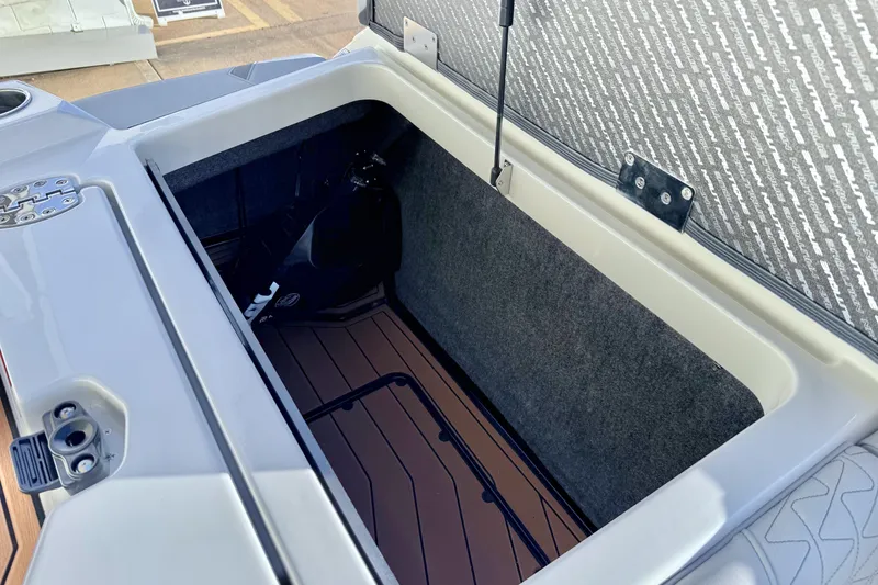 Slide: The Image of 2026 Nautique Super Air Nautique GS22 storage compartment with open lid and interior view. - 24