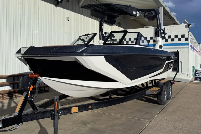 Slide: The Image of 2026 Nautique Super Air Nautique GS22 boat on trailer, black and white design. - 3