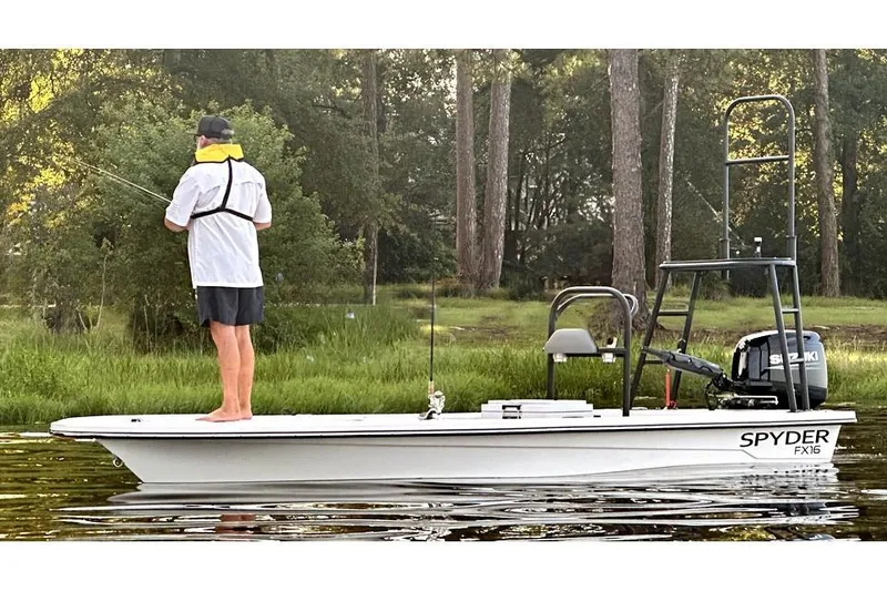 Slide: The Image of Manufacturer Provided Image: 2025 Spyder FX16 Wisp boat on calm lake with trees in background. - 2