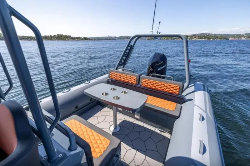 Slide: The Image of 2025 Highfield Sport 760 boat with orange seating, table, and scenic water view. - 8