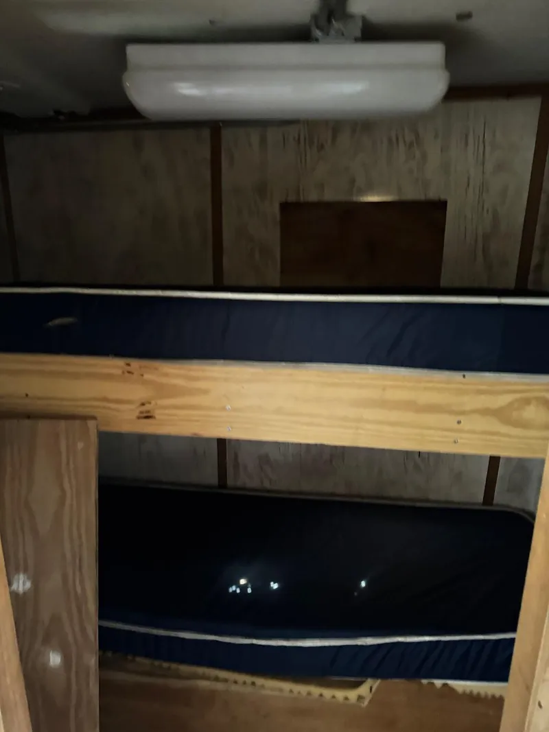 Slide: The Image of Interior of 1971 Butterfish Fishing Trawler with wooden bunk beds and overhead light. - 13