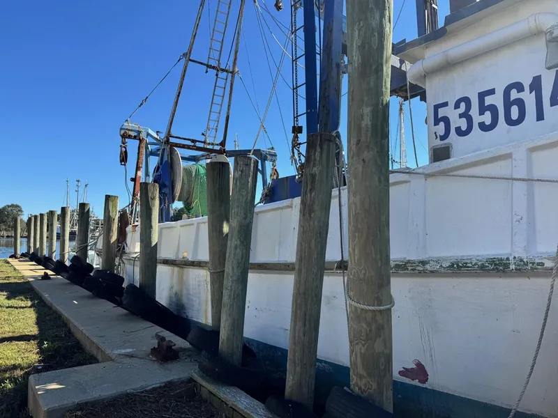 Slide: The Image of 1971 Butterfish Fishing Trawler docked at a pier under clear blue sky. - 22
