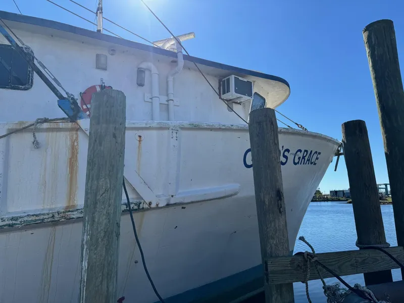 Slide: The Image of 1971 Butterfish Fishing Trawler docked at a pier under clear blue sky. - 23