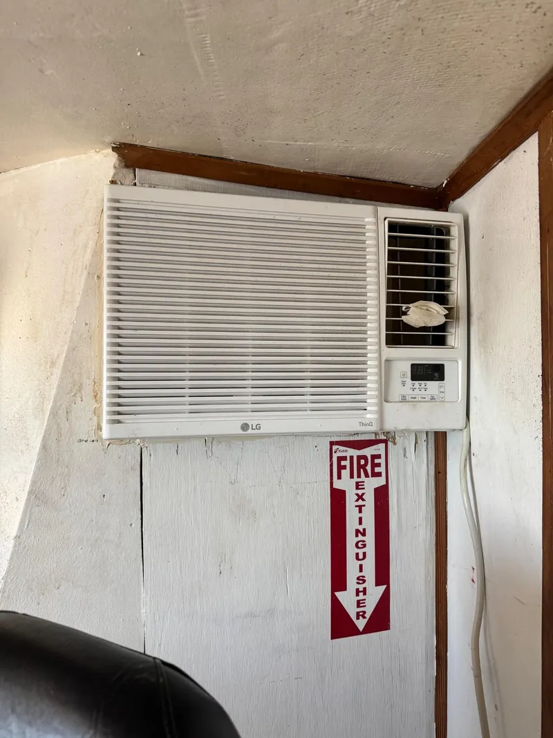 Slide: The Image of Wall-mounted air conditioner on 1971 Butterfish Fishing Trawler, with fire extinguisher sign below. - 26