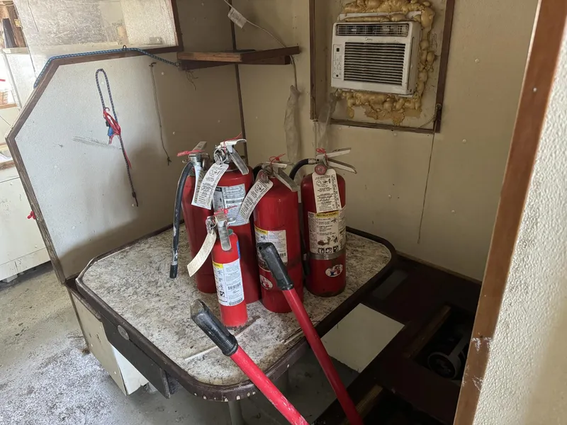 Slide: The Image of Fire extinguishers and tools on a table inside a 1972 shrimp freezer trawler. - 10