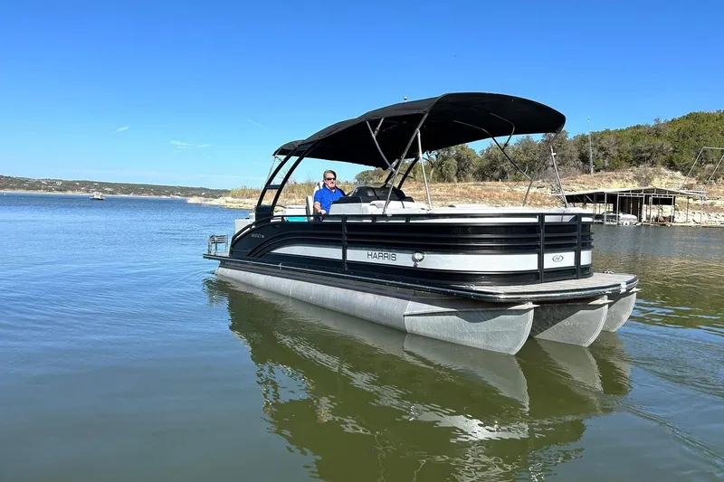 Slide: The Image of 2020 Harris FloteBote Solstice 230 pontoon boat on a serene lake. - 11