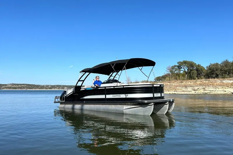 Slide: The Image of 2020 Harris FloteBote Solstice 230 pontoon boat on a calm lake under clear blue sky. - 12
