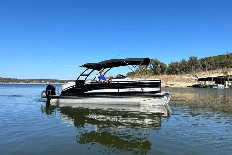 Slide: The Image of 2020 Harris FloteBote Solstice 230 pontoon boat on a calm lake under clear blue sky. - 14