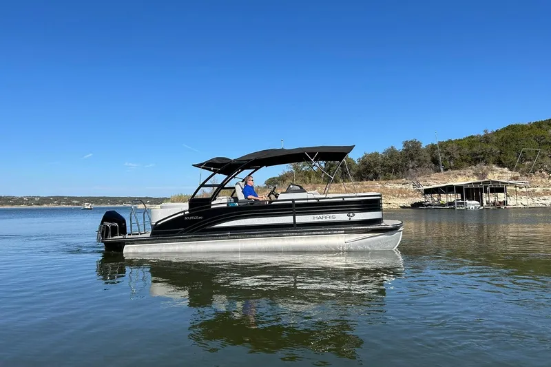 Slide: The Image of 2020 Harris FloteBote Solstice 230 pontoon boat on a serene lake. - 15