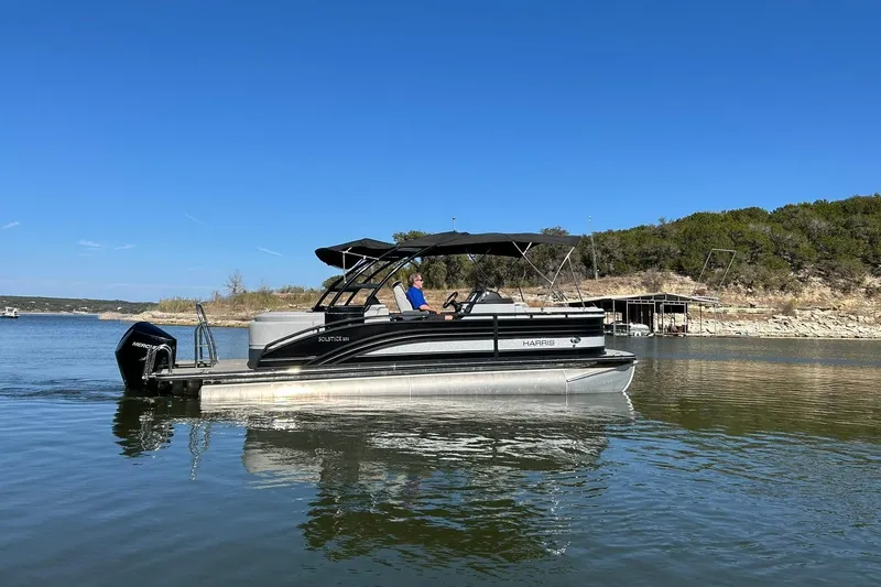 Slide: The Image of 2020 Harris FloteBote Solstice 230 pontoon boat on a serene lake. - 16