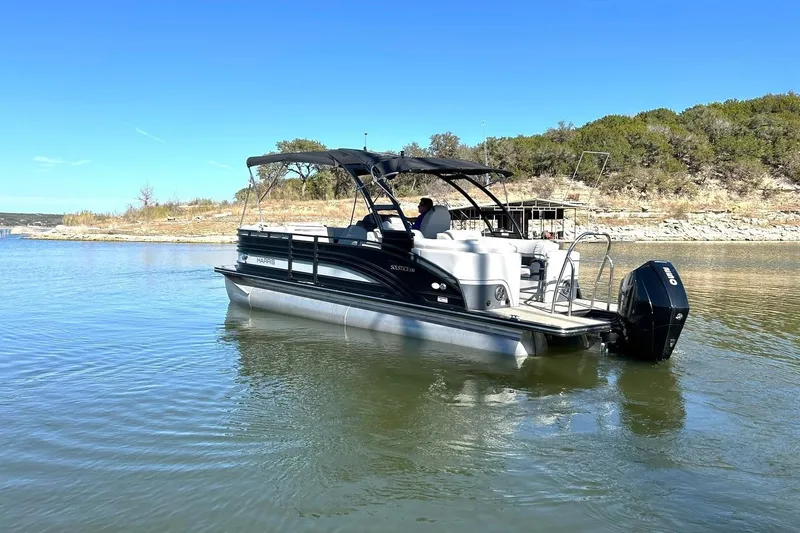 Slide: The Image of 2020 Harris FloteBote Solstice 230 pontoon boat on a calm lake. - 19