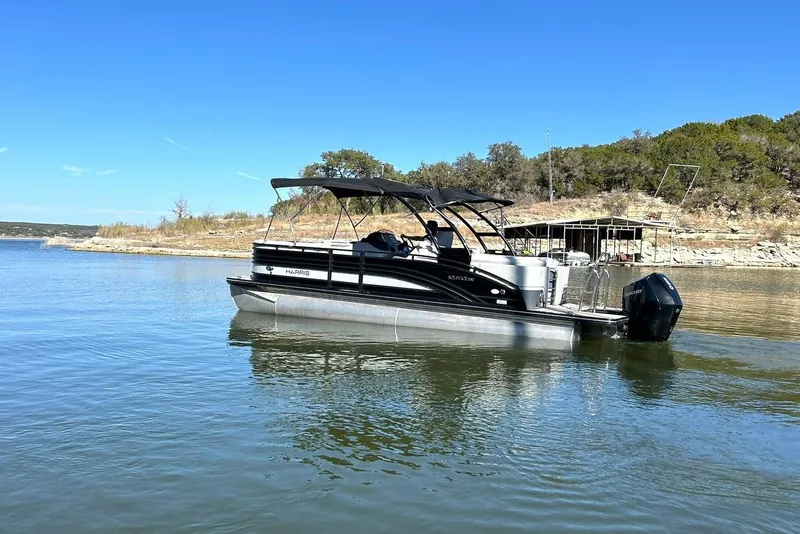 Slide: The Image of 2020 Harris FloteBote Solstice 230 pontoon boat on a serene lake. - 20