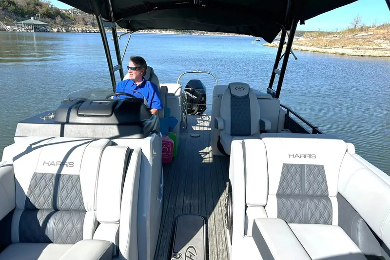 Slide: The Image of 2020 Harris FloteBote Solstice 230 on a serene lake, featuring luxurious seating and a shaded canopy. - 4