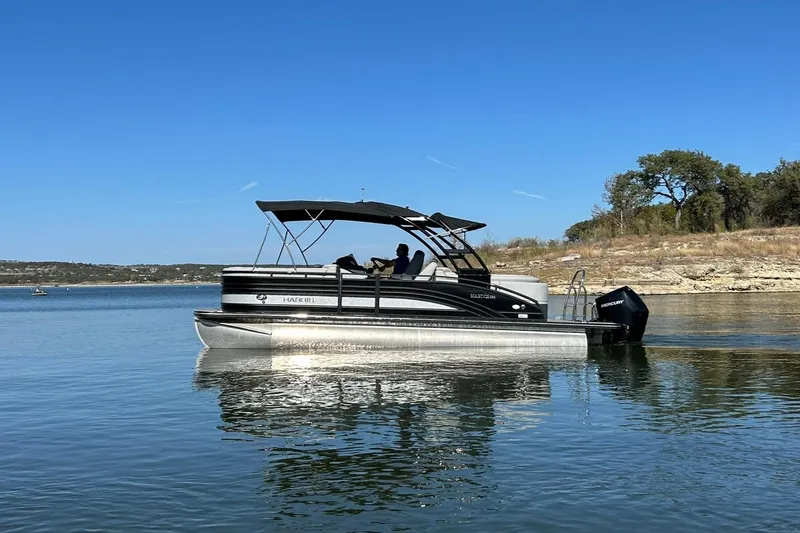 Slide: The Image of 2020 Harris FloteBote Solstice 230 pontoon boat on a calm lake under clear blue sky. - 7