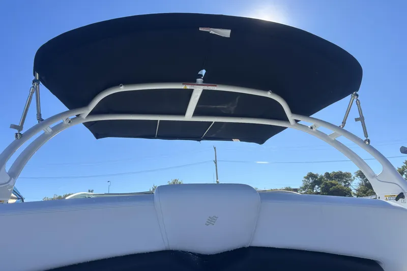 Slide: The Image of 2023 Four Winns HD3 boat with black canopy under clear blue sky. - 10
