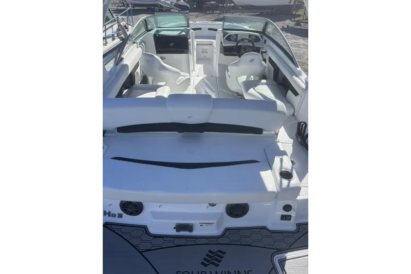 Slide: The Image of 2023 Four Winns HD3 boat interior with white seating and modern dashboard. - 11