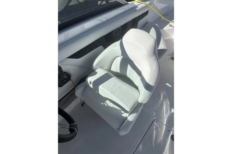 Slide: The Image of 2023 Four Winns HD3 boat interior with white seating and steering wheel. - 19