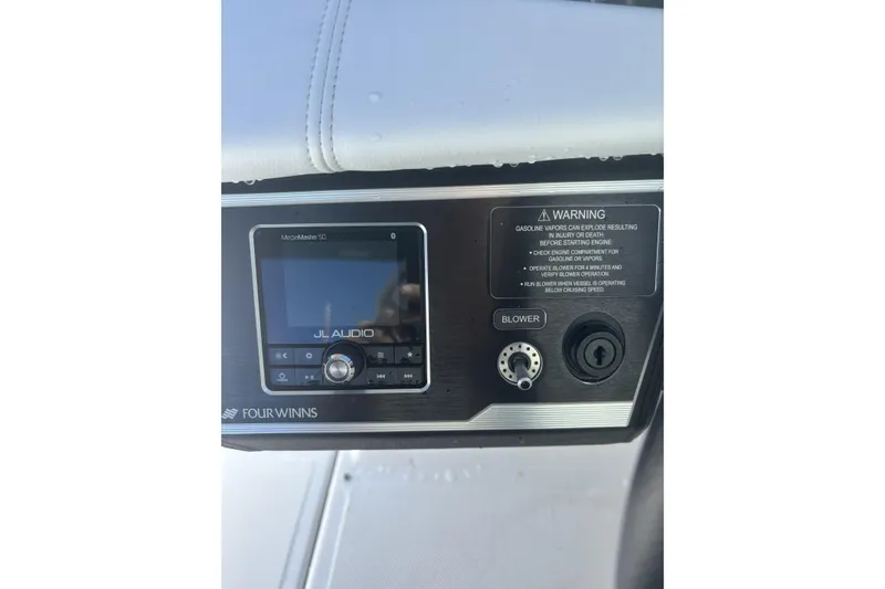 Slide: The Image of 2023 Four Winns HD3 boat dashboard with JL Audio system and safety warning. - 24