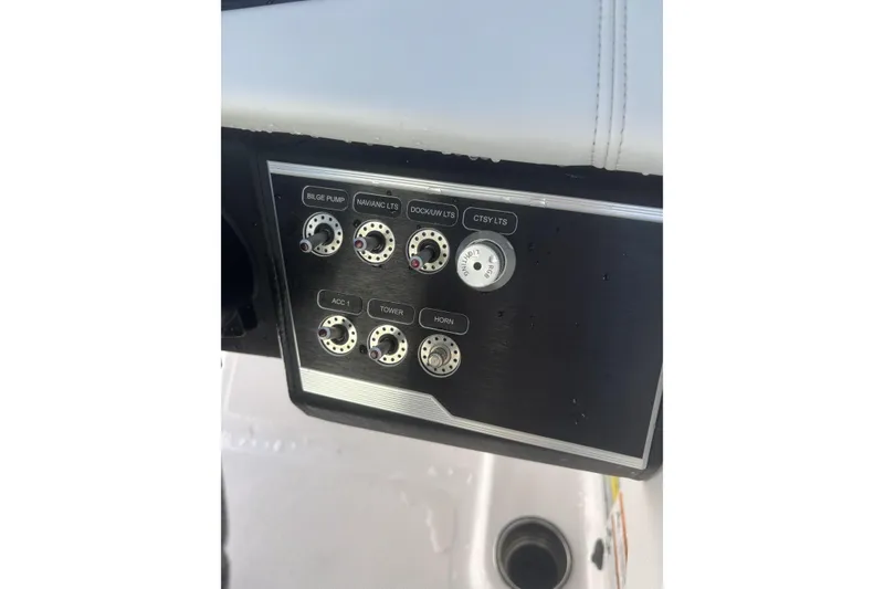 Slide: The Image of 2023 Four Winns HD3 boat control panel with labeled switches and dials. - 25