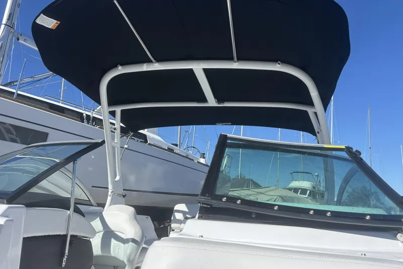 Slide: The Image of 2023 Four Winns HD3 boat with canopy, docked under clear blue sky. - 30