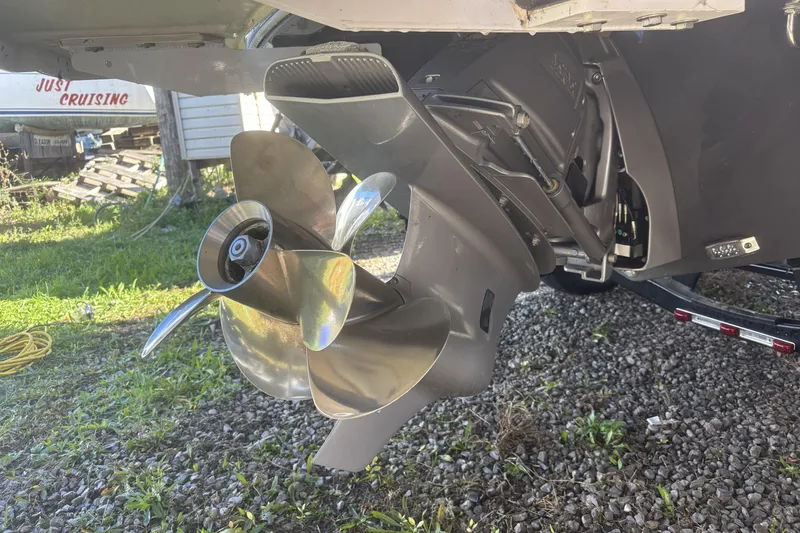 Slide: The Image of 2023 Four Winns HD3 boat propeller and outdrive on gravel surface. - 7