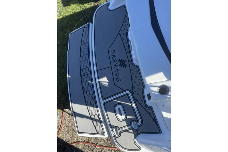 Slide: The Image of 2023 Four Winns HD3 boat deck with logo and hexagonal pattern design. - 9