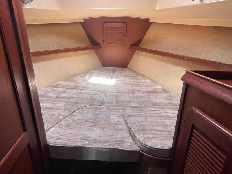 Slide: The Image of 1990 Island Packet 35 Cutter forward cabin with V-berth and wooden accents - 11