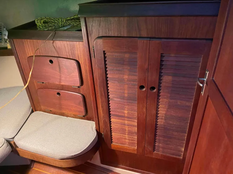Slide: The Image of Interior of 1990 Island Packet 35 Cutter with wooden cabinets and cushioned seating. - 15