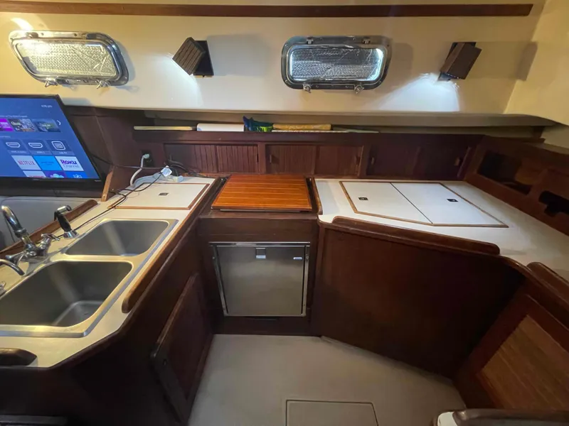 Slide: The Image of Interior of 1990 Island Packet 35 Cutter sailboat with dining area and wooden cabinetry. - 27