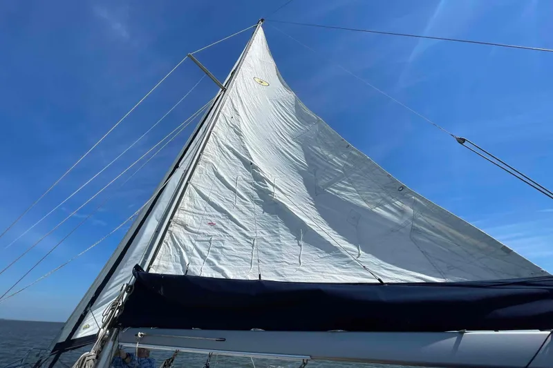 Slide: The Image of 1990 Island Packet 35 Cutter sailboat cockpit with seating and steering wheel. - 67