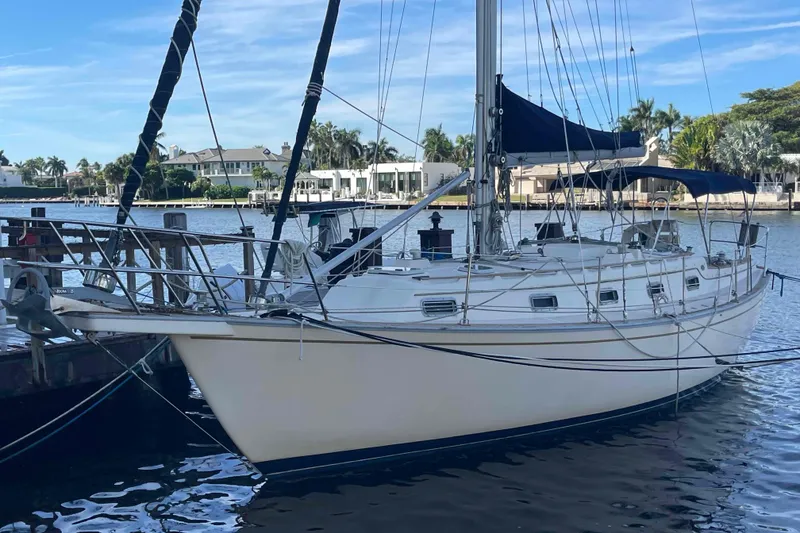Slide: The Image of 1990 Island Packet 35 Cutter sailboat docked by waterfront homes. - 78