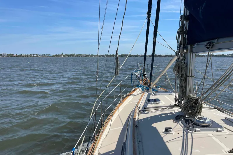 Slide: The Image of Sailing on a 1990 Island Packet 35 Cutter in calm waters under a clear sky. - 85