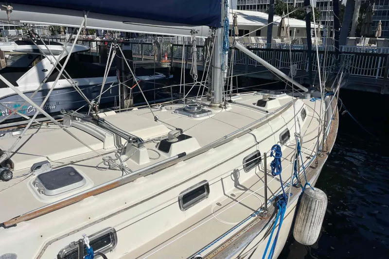 Slide: The Image of 1990 Island Packet 35 Cutter sailboat docked at marina, showcasing deck and rigging. - 87