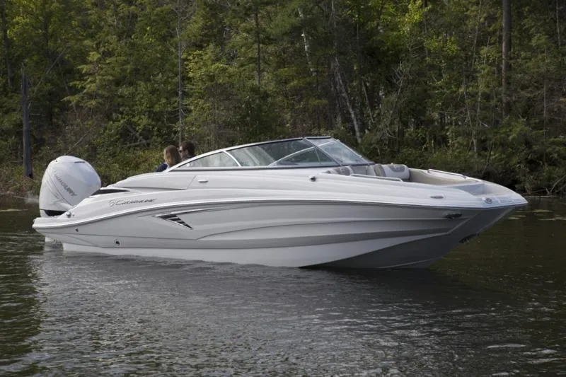Slide: The Image of 2023 Crownline Eclipse E235 XS boat on a serene lake with forest backdrop. - 3