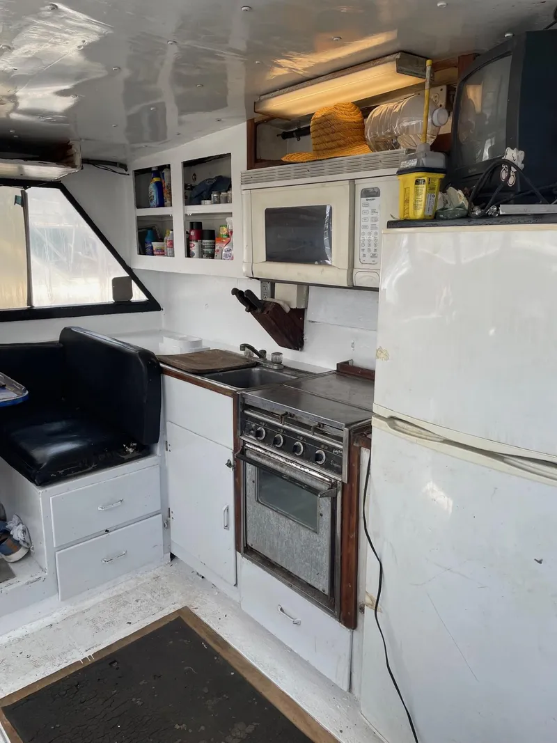 Slide: The Image of Compact boat kitchen with stove, microwave, and fridge; 1983 Commercial Hull #1 Key West model. - 2