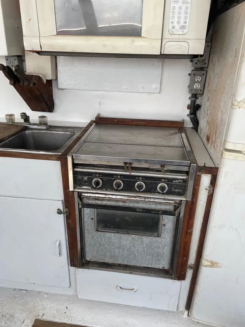 Slide: The Image of 1983 commercial boat kitchen with stove, sink, and microwave. - 3