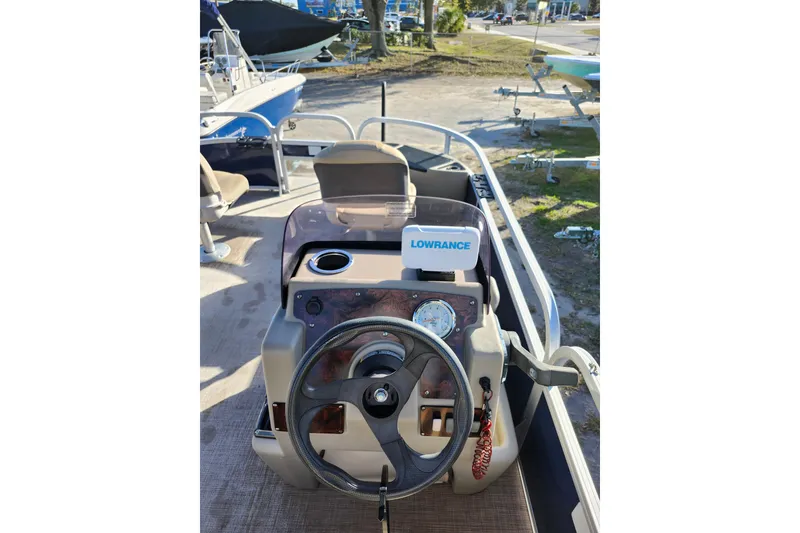 Slide: The Image of 2022 Sun Tracker Bass Buggy 16 XL Select boat dashboard with steering wheel and Lowrance device. - 16