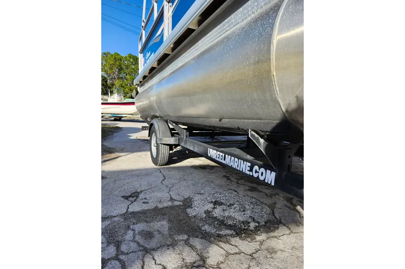 Slide: The Image of 2022 Sun Tracker Bass Buggy 16 XL Select on trailer, side view, outdoor setting. - 27