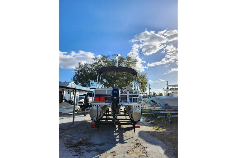 Slide: The Image of 2022 Sun Tracker Bass Buggy 16 XL Select pontoon boat under a clear blue sky. - 5