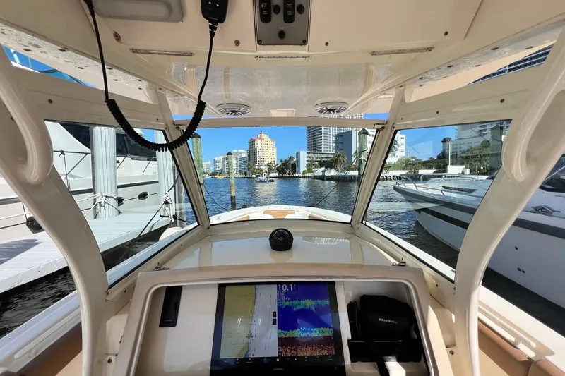 Slide: The Image of Interior view of 2013 Scout 275 LXF boat with navigation display, docked in marina. - 10