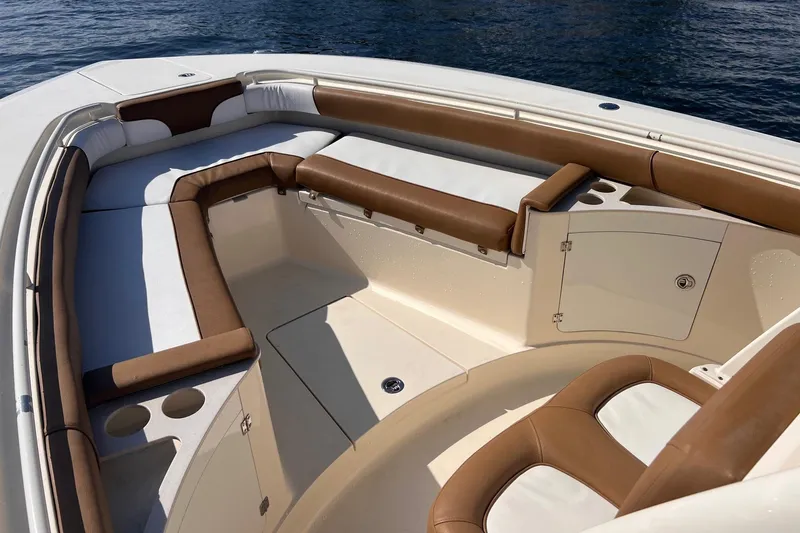 Slide: The Image of 2013 Scout 275 LXF boat interior with brown and white seating, on calm water. - 15