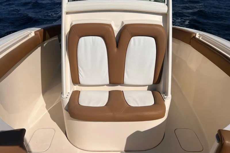 Slide: The Image of 2013 Scout 275 LXF boat interior with tan and white cushioned seating. - 16
