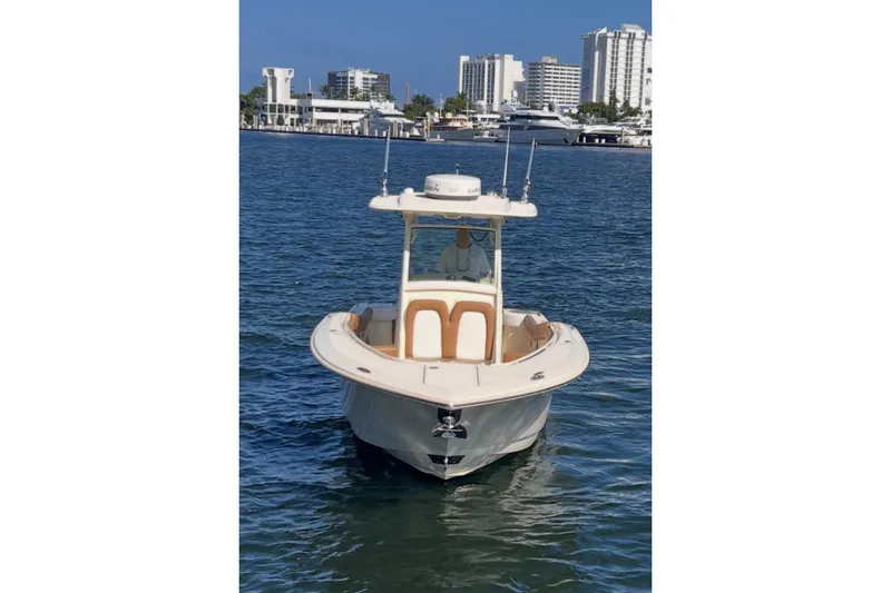 Slide: The Image of 2013 Scout 275 LXF boat on water with city skyline background. - 19