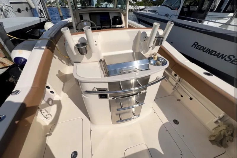 Slide: The Image of 2013 Scout 275 LXF boat interior with fishing rod holders and storage drawers. - 3
