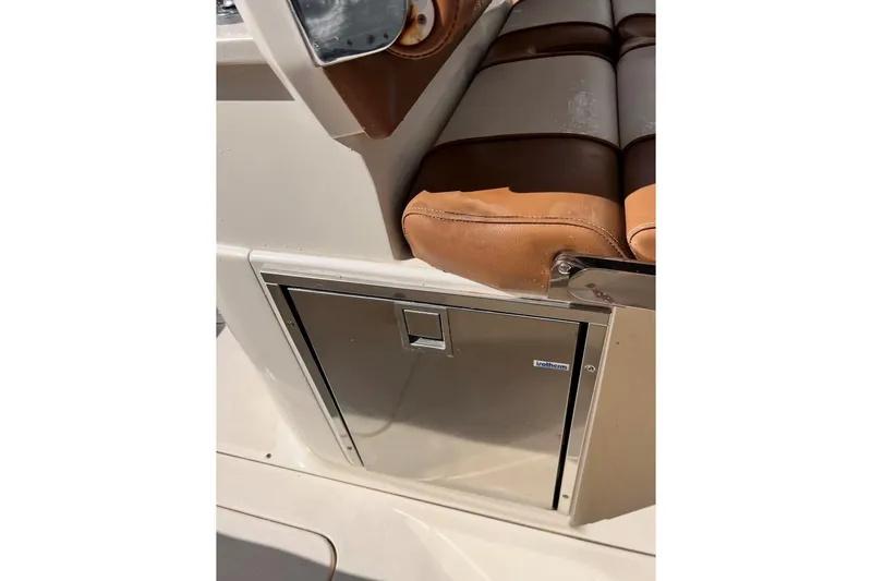 Slide: The Image of 2013 Scout 275 LXF boat interior with brown seating and stainless steel compartment. - 5